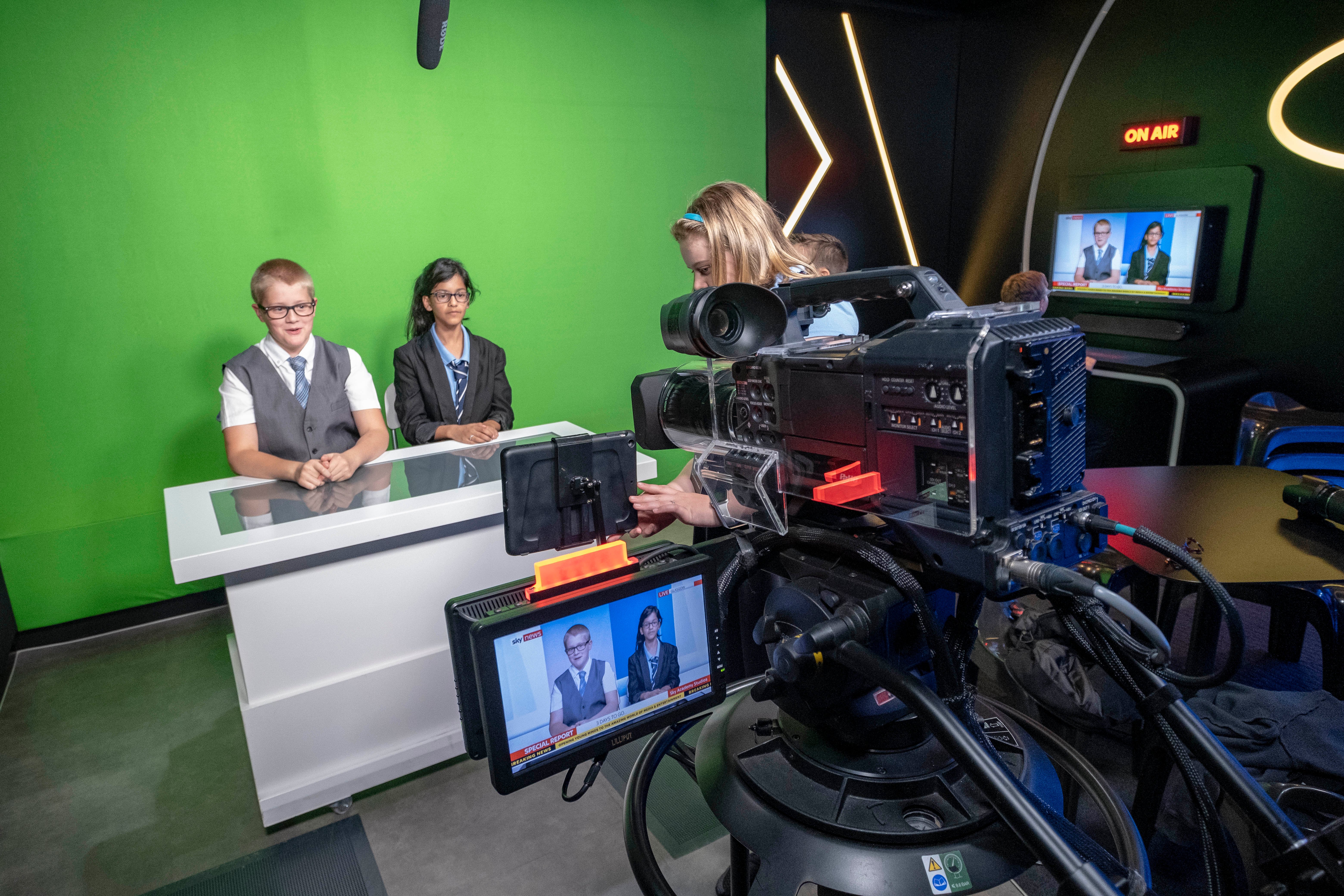 students presenting in a studio in front of a green screen