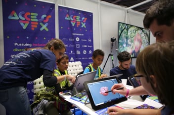 an image of people teaching children how to create VFX on tablets