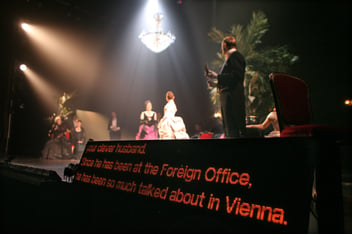 a captioning device at the front of a stage where a performance is taking place