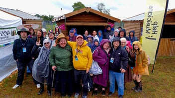 a group of participants of The Black Box in a field outside of a shed-like building